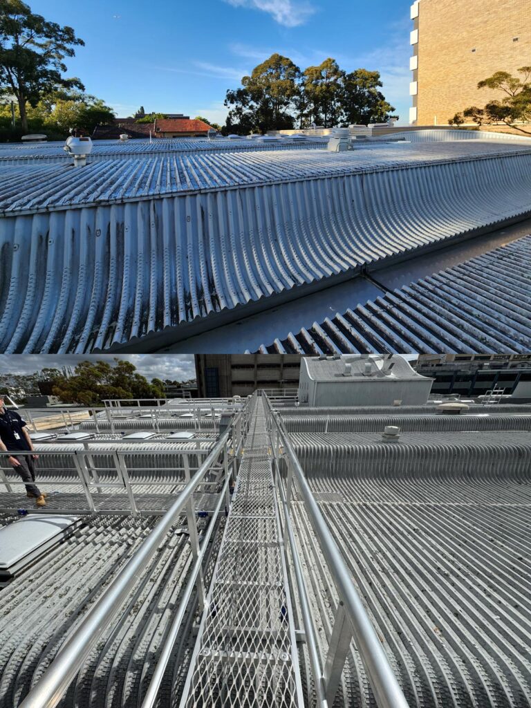 A low-angle view of a modern buildings metallic roof and walkway with a person standing on it.